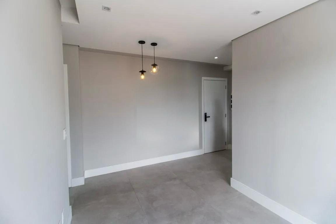 Sala de estar e jantar com porcelanato e luminária pendente